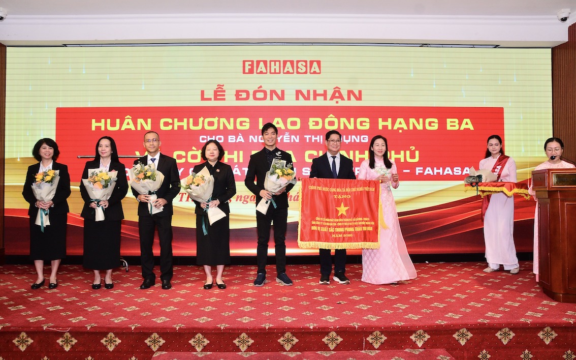Các thành viên lãnh đạo công ty Fahasa đón nhận cờ thi đua của Chính Phủ