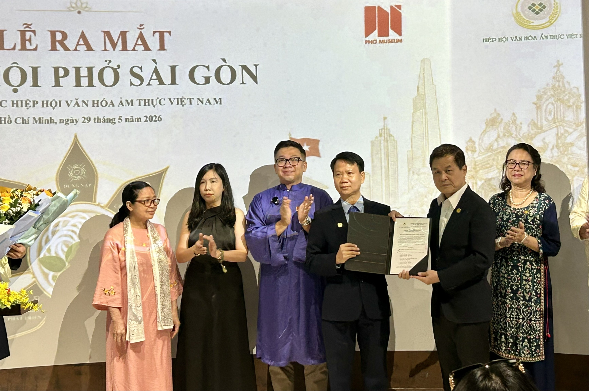 Ông Nguyễn Quốc Kỳ - Chủ tịch Hiệp hội Văn hóa Ẩm thực Việt Nam trao quyết định thành lập Chi hội Phở Sài Gòn. Ảnh: Cẩm Viên. 
