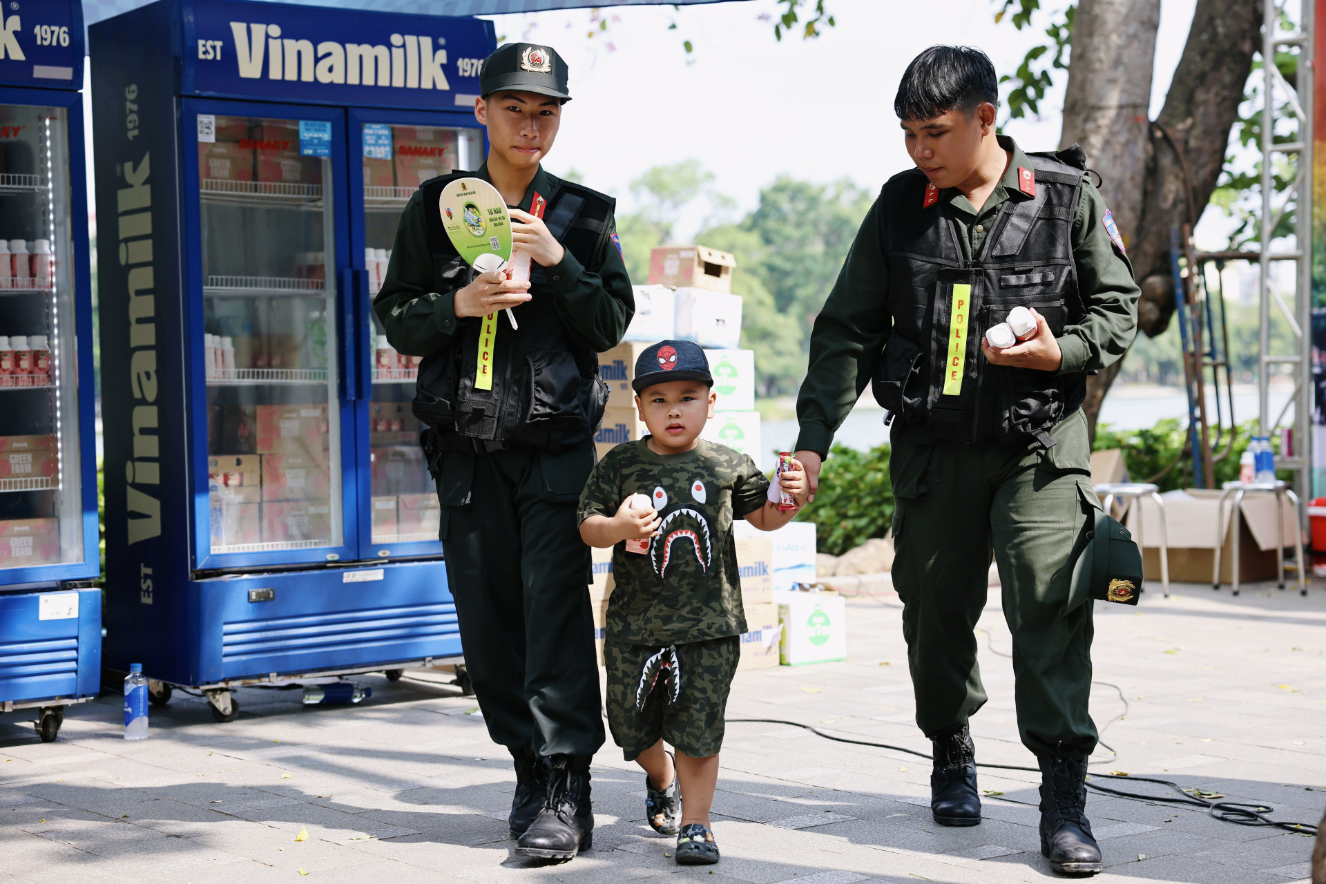 Em bé được lực lượng cảnh sát cơ động chăm sóc, trao tặng sản phẩm dinh dưỡng Vinamilk tại chương trình. Ảnh: Vi Nam.