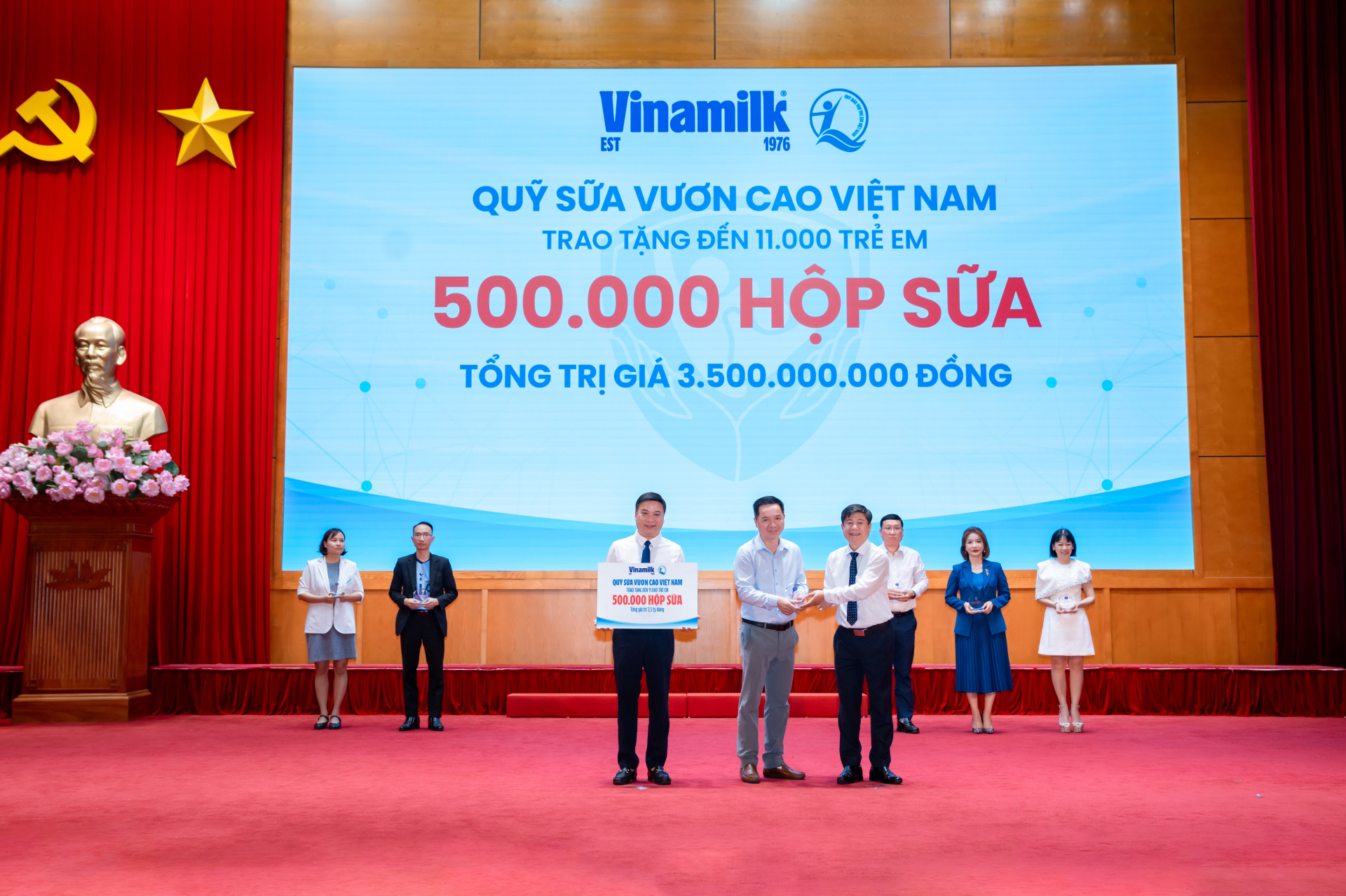 Đại diện Vinamilk (đứng giữa) trao bảng tượng trưng 500.000 hộp sữa và nhận kỷ niệm chương từ Bộ Y tế (Ảnh: VN).
