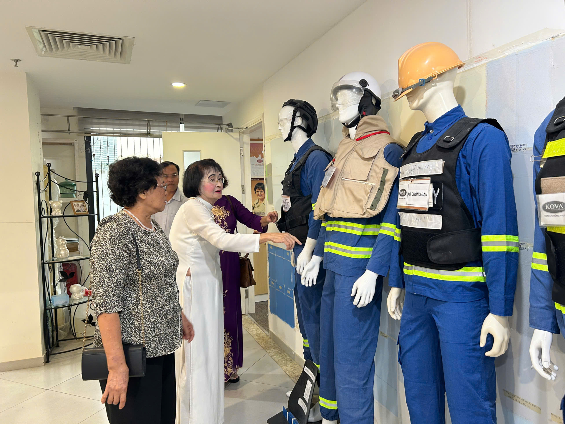PGS.TS Nguyễn Thị Hòe giới thiệu các loại áo chống đạn, chóng cháy do chính bà nghiên cứu sản xuất. Ảnh: Cẩm Viên. 