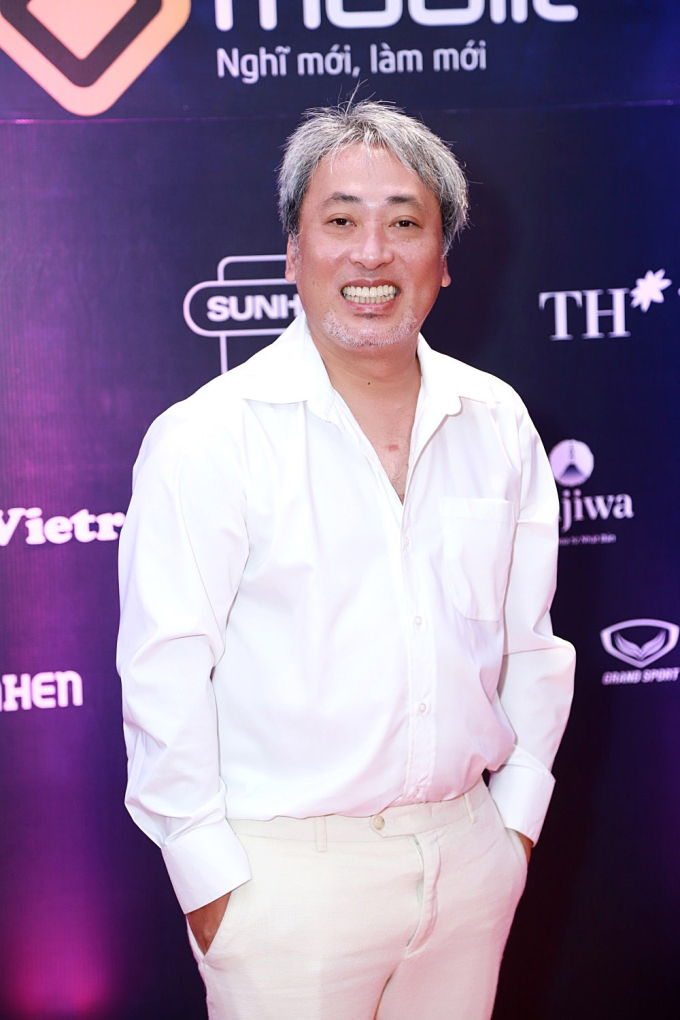 Đạo diễn Nguyễn Quang Dũng diện cây trắng tạo dáng trên thảm đỏ