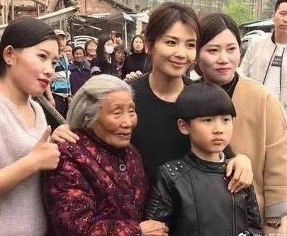 Lưu Đào lên đồ đơn giản, nở nụ cười thân thiện chụp hình chung với hàng xóm khi cùng gia đình về quê thăm người thân nhân dịp Tết Nguyên đán