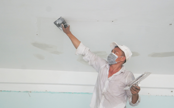 Công nhân sơn, sửa trần nhà tại trường THCS Minh Đức, quận 1 sau thời gian làm khu điều trị F0. Ảnh: vnexpress