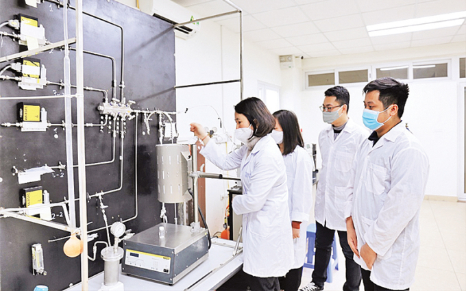 GS.TS Lê Minh Thắng cùng các cộng sự trong phòng thí nghiệm bên sơ đồ công nghệ xử lý khí thải. Ảnh: Ngô Hà/ KHPT