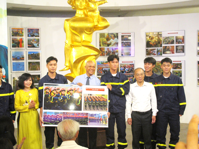 Nhiếp ảnh gia Nguyễn Á tặng Bảo tàng Phụ nữ VN bức ảnh chụp các chiến sĩ cảnh sát Phòng cháy, chữa cháy và Cứu hộ, cứu nạn. Ảnh: L.Q.V 