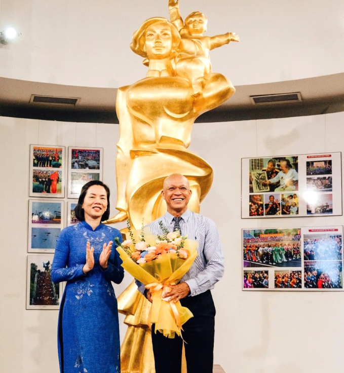 Bà Nguyễn Thị Minh Hương - Phó Chủ tịch Hội Liên hiệp Phụ nữ Việt Nam - tặng hoa chúc mừng nhiếp ảnh gia Nguyễn Á. Ảnh: L.Q.V 