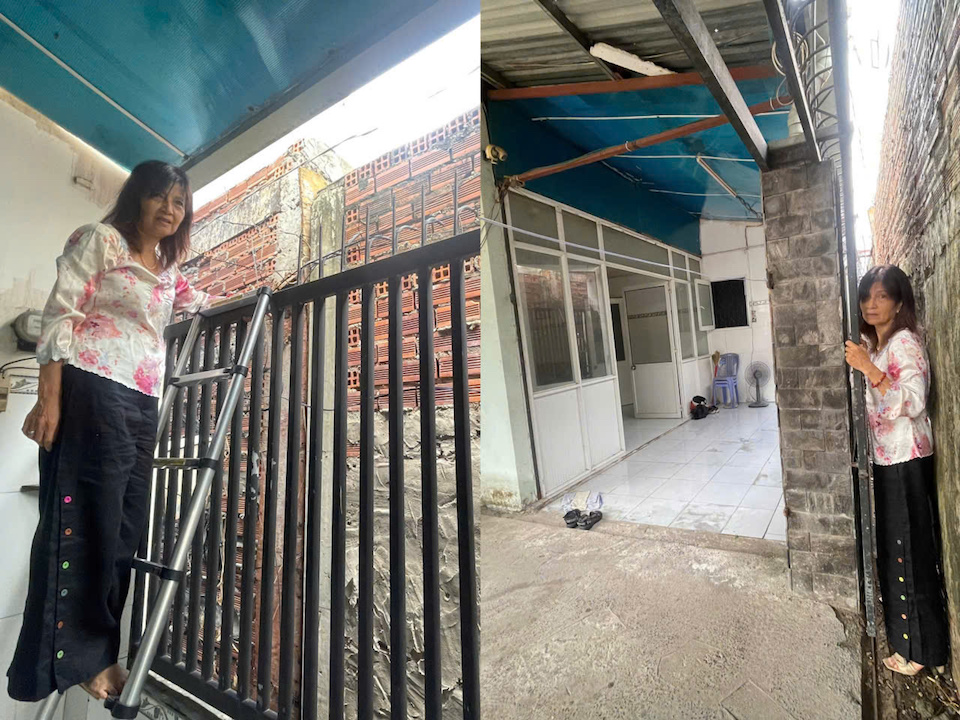 Bà Đỗ Ngọc Cự leo cầu thang, đứng trong khe hẹp, lối đi duy nhất còn sót lại để vào nhà, nơi mà một người trưởng thành cũng khó lòng đi lọt. Ảnh: Tiểu Thúy