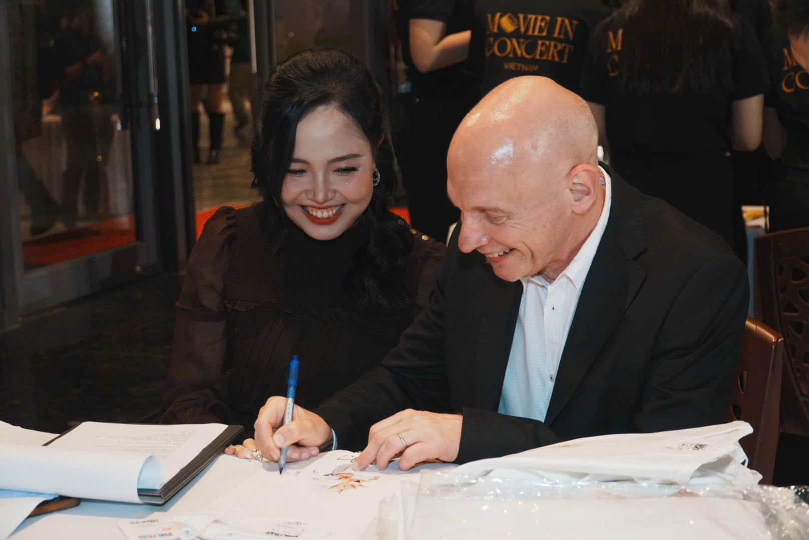 ông Jean Thorel nhạc trưởng người Pháp đang ký tặng áo cho khán giả trước sự kiện.