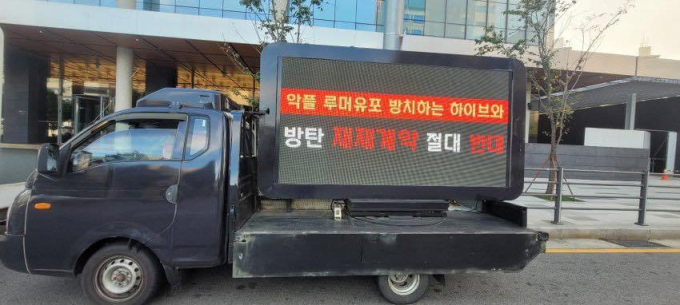 Loạt xe tải phản đối việc tái ký của BTS trước cổng HYBE khiến fan bất bình