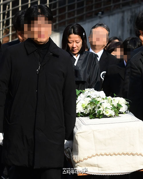 Bà xã Jeon Hye Jin nắm tay con trai út ở phía sau quan tài. Nữ diễn viên tiều tụy, suy sụp sau hàng loạt biến cố xảy đến