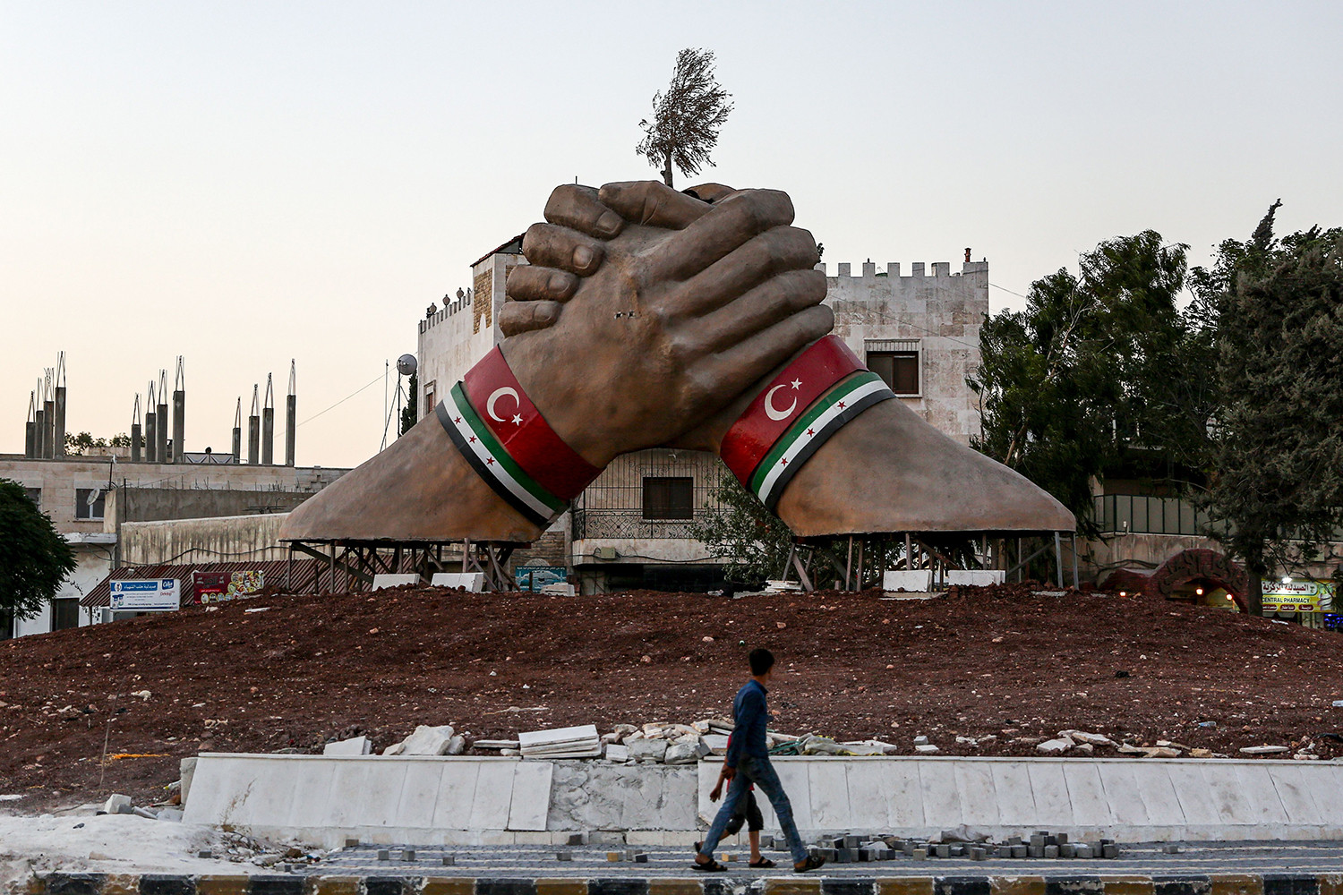   Một tác phẩm điêu khắc khổng lồ nổi bật với những chiếc vòng đeo tay cho thấy cờ phiến quân Thổ Nhĩ Kỳ và Syria đứng trong một vòng xoay ở thị trấn Azaz ở trung tâm vùng ảnh hưởng của Thổ Nhĩ Kỳ ở tỉnh Aleppo phía bắc Syria gần biên giới Thổ Nhĩ Kỳ vào ngày 27/7.  