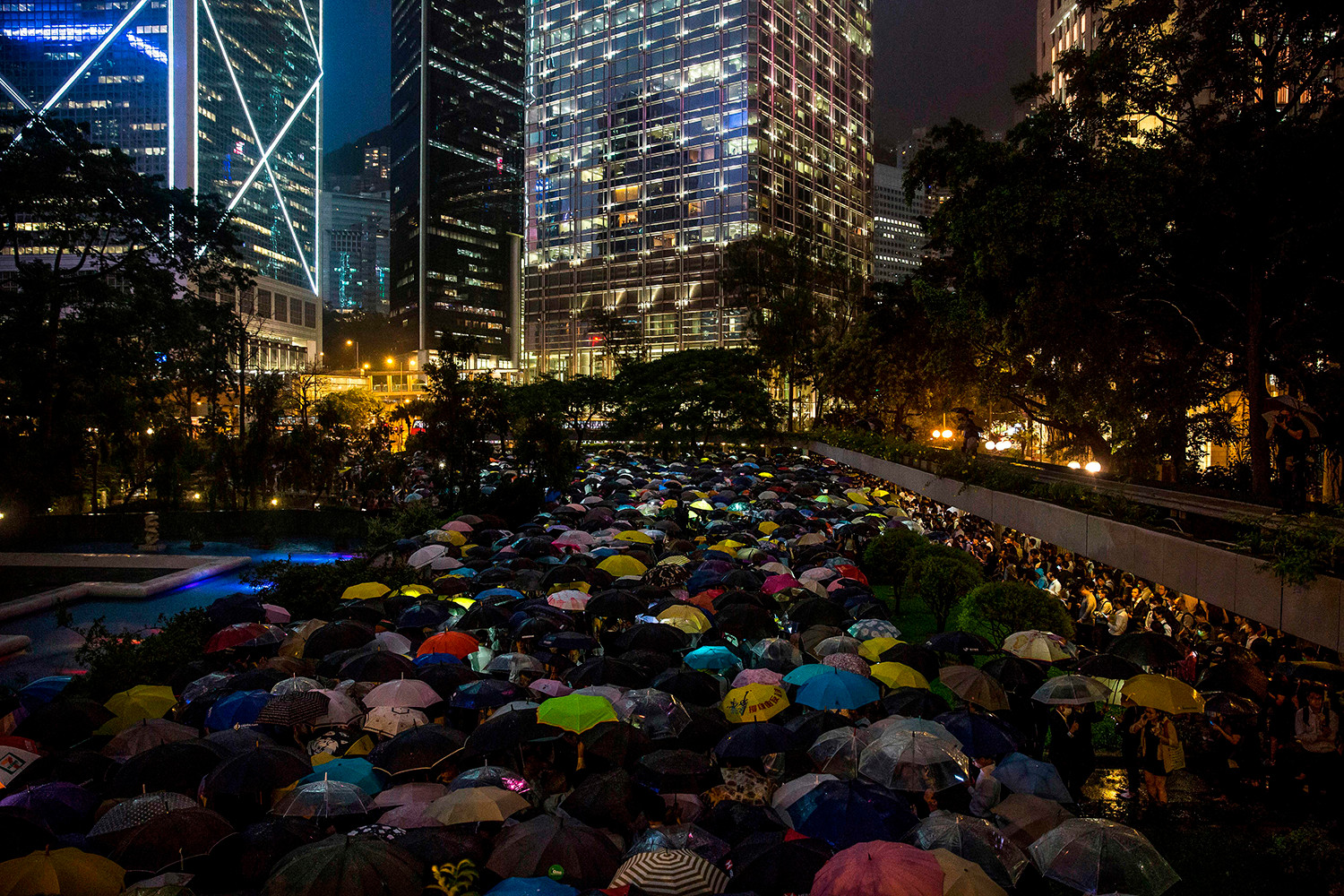 Những người từ cộng đồng tài chính cầm ô và chiếu đèn trong cuộc biểu tình phản đối dự luật dẫn độ gây tranh cãi ở Hồng Kông vào ngày 1/8.