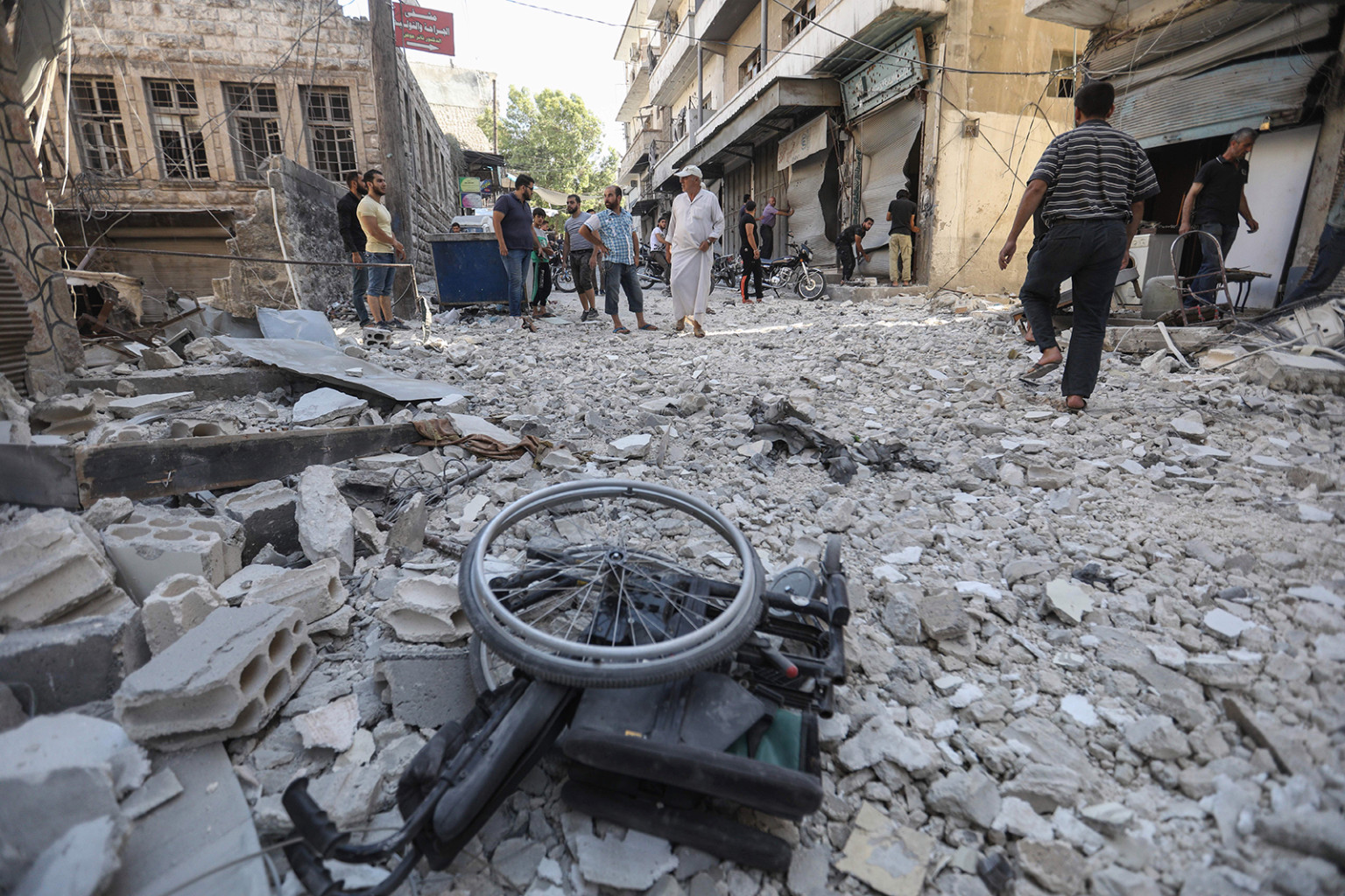 Một chiếc xe lăn nằm giữa đống đổ nát của các tòa nhà bị phá hủy sau cuộc không kích được báo cáo ở thị trấn Ariha, phía nam tỉnh Idlib của Syria, vào ngày 24/7.