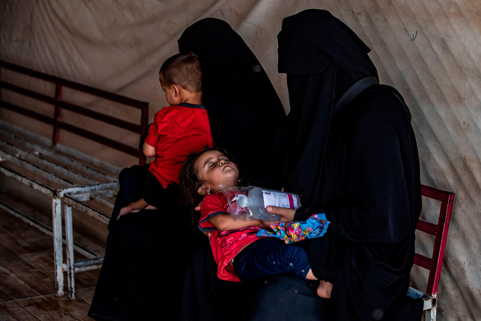 Các bà mẹ Syria di tản bế con khi họ chờ đợi bên ngoài một phòng khám ở trại al-Hol cho những người di tản nội bộ ở Hasakeh cai quản vùng đông bắc Syria vào ngày 23/7.