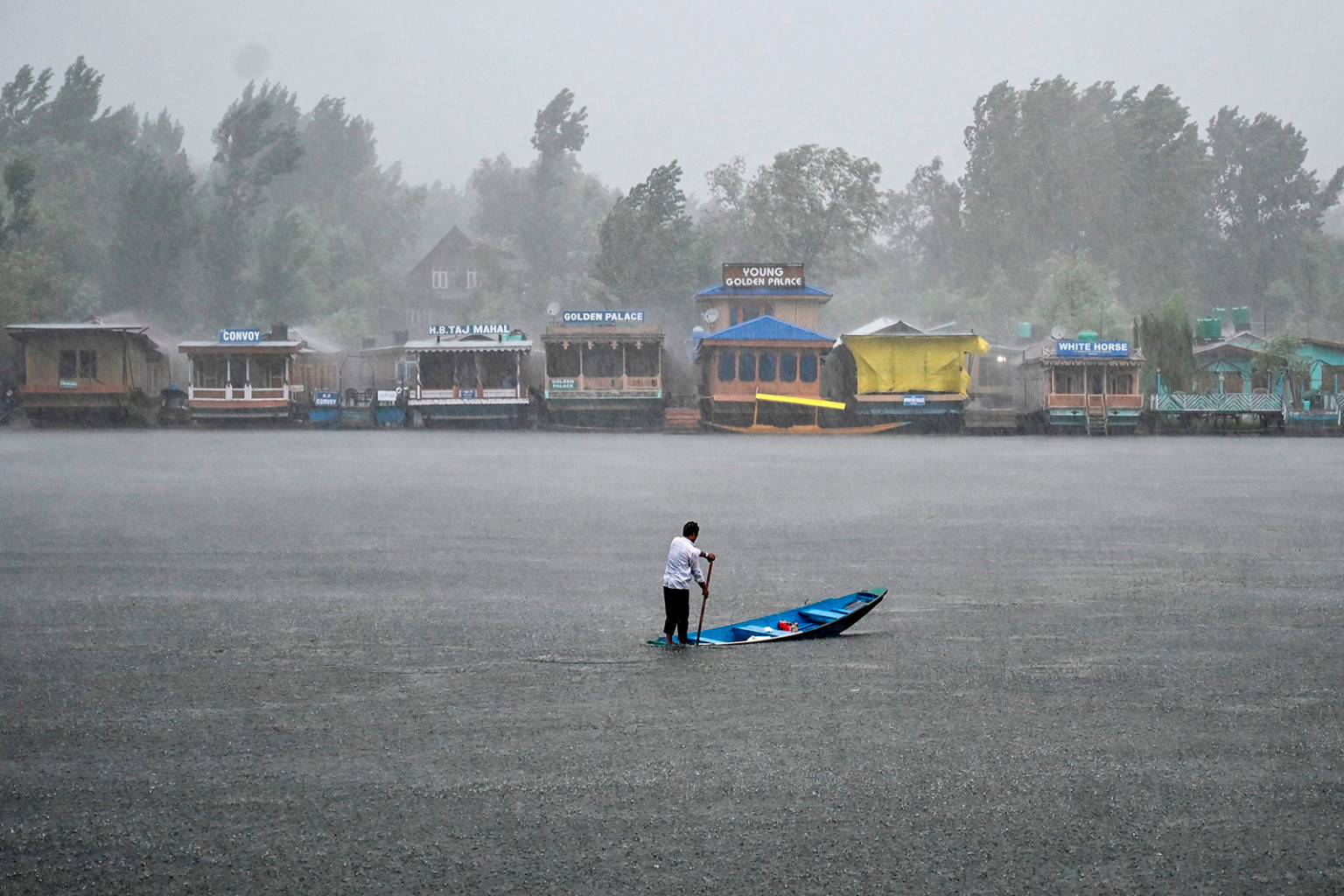  người dân chèo thuyền trên hồ Dal trong trận mưa lớn ở Srinagar, Ấn Độ, vào ngày 25/7.