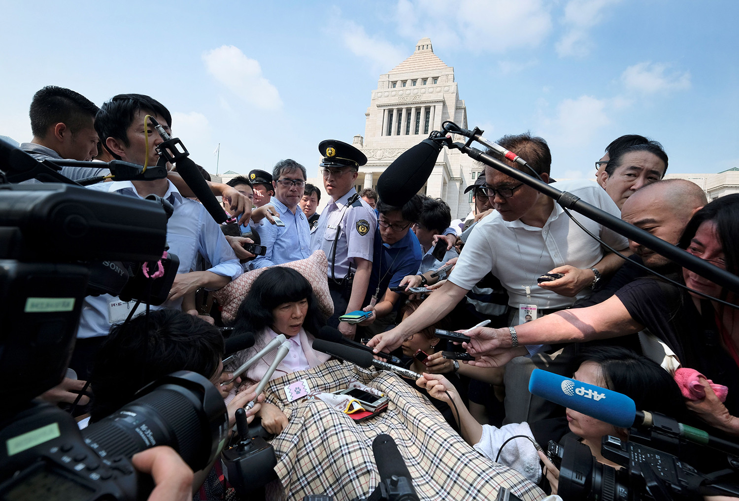   Nhà lập pháp Nhật Bản Eiko Kimura bị bao vây bởi các phương tiện truyền thông khi cô đến Quốc hội ở Tokyo vào ngày 1/8. Hai nhà lập pháp bị tê liệt nghiêm trọng đã ngồi vào thượng viện của Nhật Bản để cổ vũ những người ủng hộ, đánh dấu lần đầu tiên những người khuyết tật vào Thượn viện.  