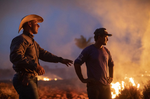 Hai công nhân ở bang Mato Grosso, phía nam lưu vực sông Amazon ở Brazil, nhìn đám cháy lan đến trang trại họ làm việc hôm 23/8. Ảnh: AFP.