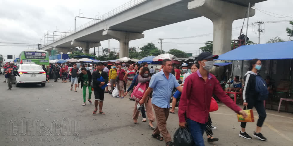 Người dân chờ xe buýt trước cổng khu du lịch Suối Tiên để về lại trung tâm.