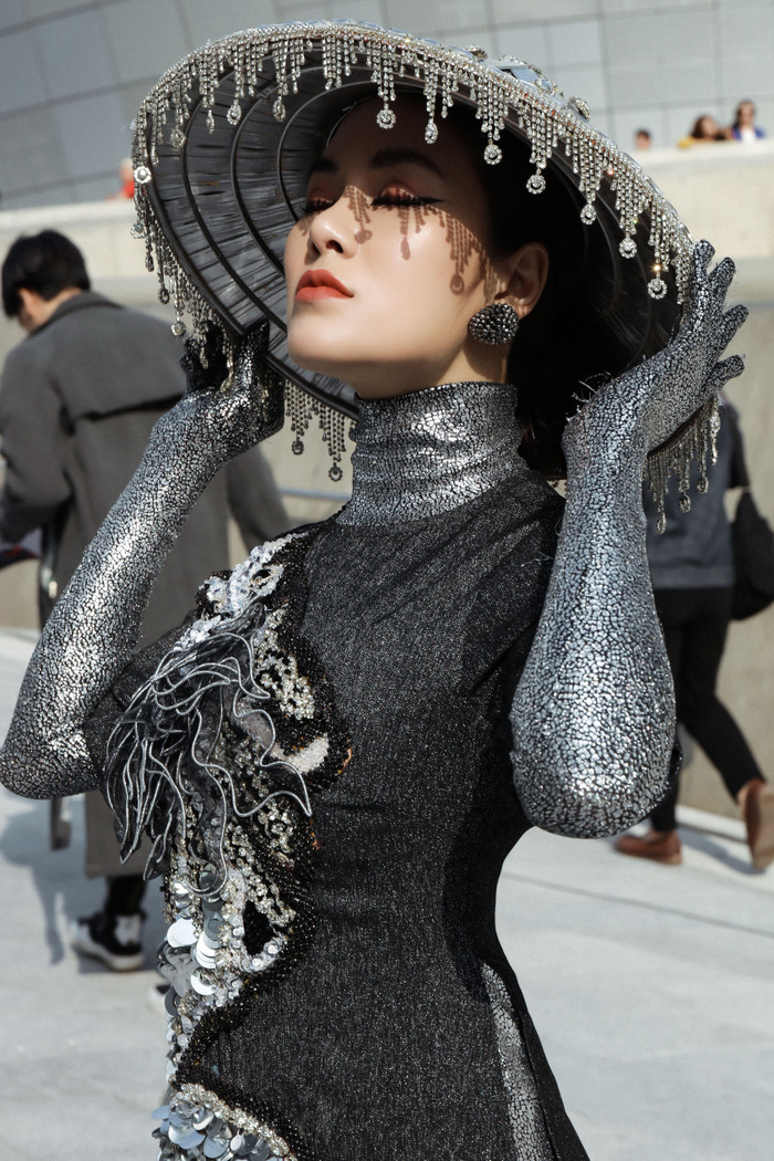 Người đẹp khoác lên mình bộ cánh tạo hình rồng uốn lượn bằng kim loại của NTK Lý Liên Kiệt với điểm nhấn là chiếc nón lá đính gương lấp lánh. Trang phục ngay lập tức thu hút sự chú ý của giới mộ điệu cũng như cánh kí giả tại Hàn. Cô được nhận định là một nhân tố sáng giá tại tuần lễ thời trang Seoul Fashion Week 2019.