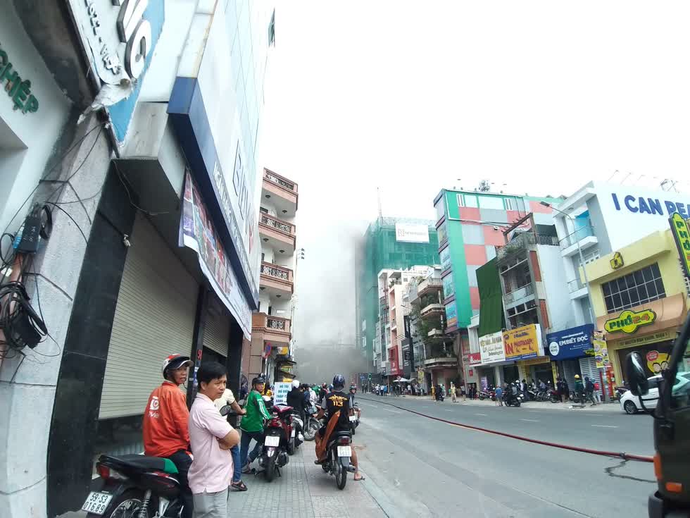 Người dân di chuyển ra xa khu vực cháy để tránh bị khói gây ảnh hưởng đến sức khỏe