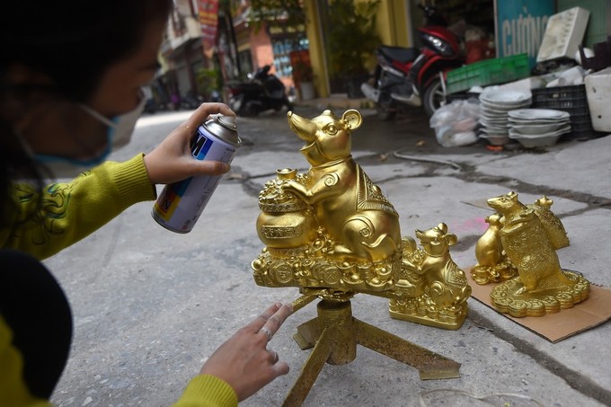 Một nữ nghệ nhân Việt Nam hoàn thiện những bức tượng chuột vàng để bán dịp Tết Canh Tý.