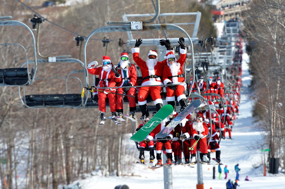 Du khách trượt tuyết hóa trang thành ông già Noel đi thang máy trượt tuyết trong sự kiện trượt tuyết từ thiện Santa và Chủ nhật hàng năm tại Newry, Maine, vào ngày 8/12. Ảnh:  AFP / Getty.