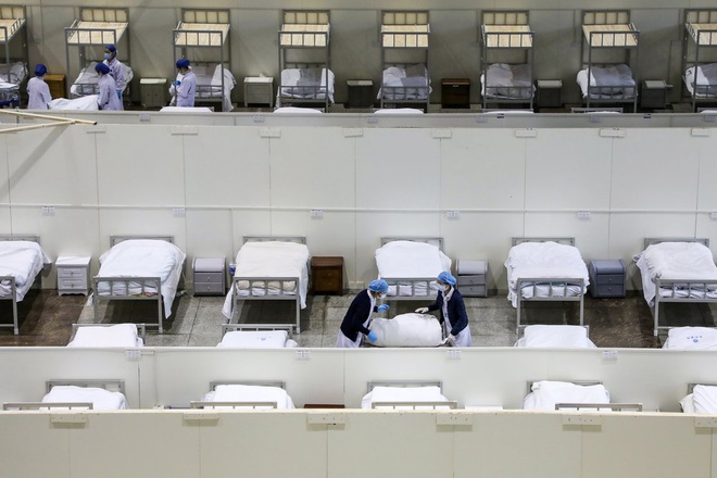 Các y tá đang chuẩn bị giường trong bệnh viện dã chiến được cải tạo từ một trung tâm triển lãm ở Vũ Hán để điều trị bệnh nhân virus corona. Ảnh: AP.