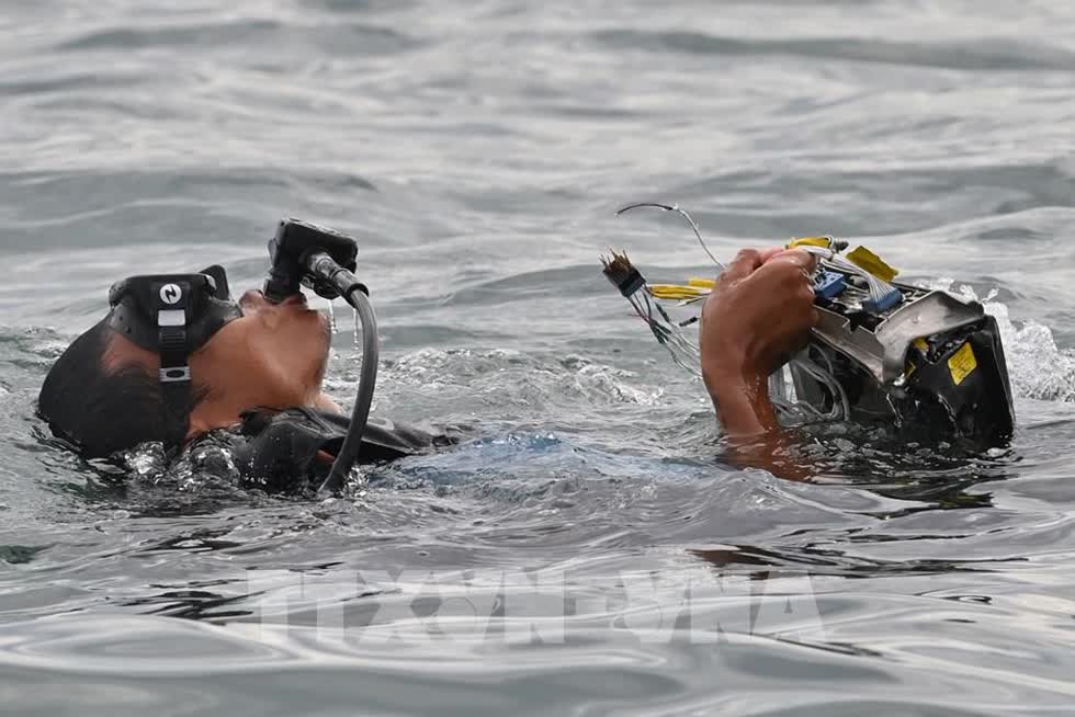   Thợ lặn thuộc các lực lượng hải quân tìm kiếm các mảnh vỡ chiếc máy bay gặp nạn tại vùng biển gần đảo Lancang, Indonesia, ngày 10/1/2021. Ảnh: AFP/TTXVN.  