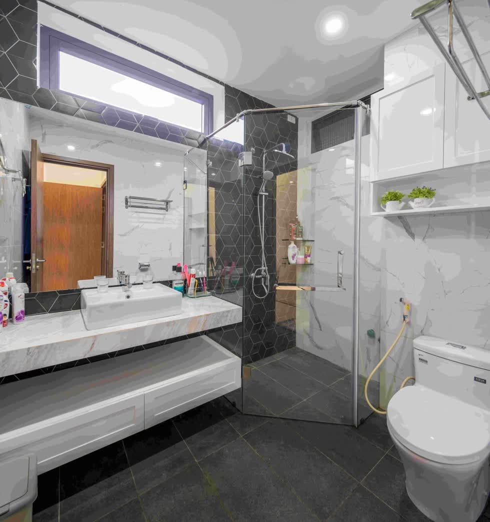 Phòng vệ sinh được phân chia hai khu vực khô - ướt nhờ phòng tắm kính .