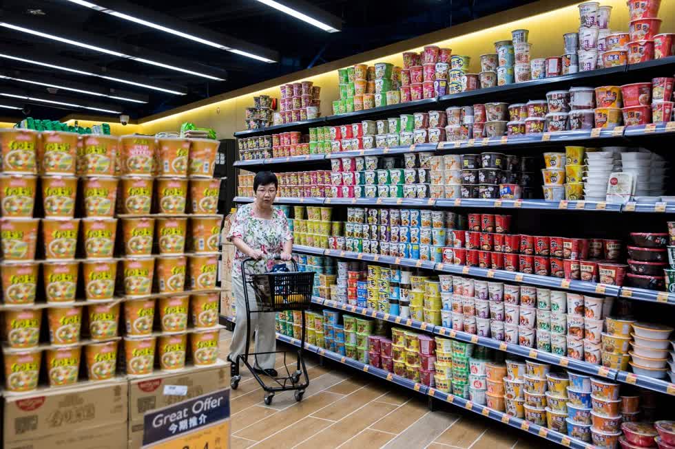 Một người mua sắm đi ngang qua các nhãn hiệu mì ăn liền khác nhau bày bán trong một siêu thị ở Hồng Kông vào ngày 17/8/2017.
