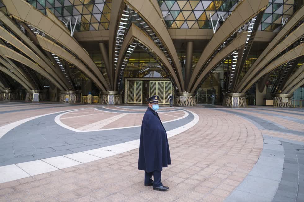 Và đây là hình ảnh một nhân viên bảo vệ đeo khẩu trang đứng trước Sòng bạc Grand Lisboa ở Macau vào ngày 5/2/2020. Bên ngoài vắng lặng từ khi dịch bệnh do virus Corona (2019-nCoV) bùng phát.  Ảnh: Bloomberg.