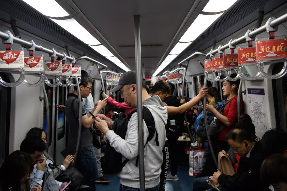 Hành khách trên một chuyến tàu trong tàu điện ngầm Bắc Kinh vào ngày 25/4/2018. Ảnh: Bloomberg.