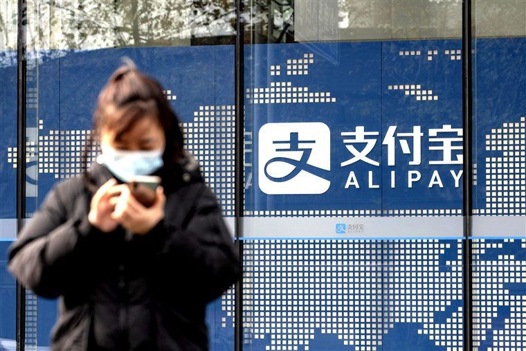 Một người đi bộ đứng trước biển báo Alipay bên ngoài tòa nhà văn phòng Ant Group Co. ở Thượng Hải, Trung Quốc, vào ngày 24/12/2020. Ảnh: Bloomberg