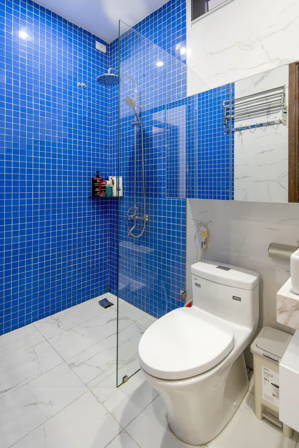 Phòng vệ sinh ở tầng 2 được tạo điểm nhấn bằng gạch thẻ xanh đi ron trắng .