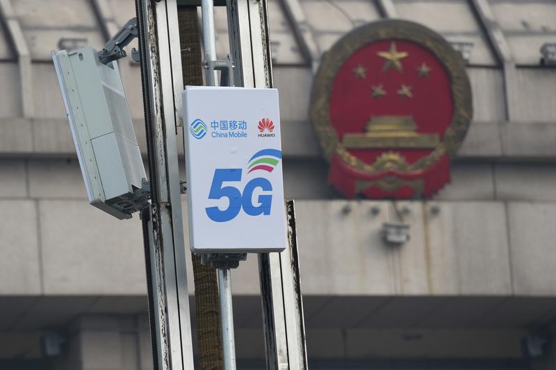 Các đơn vị ăng-ten hoạt động 5G có logo của China Mobile và Huawei được nhìn thấy trước trung tâm hội nghị Đại hội Nhân dân Toàn quốc (NPC) ở Lạc Dương, tỉnh Hà Nam, Trung Quốc. Ảnh: Reuters