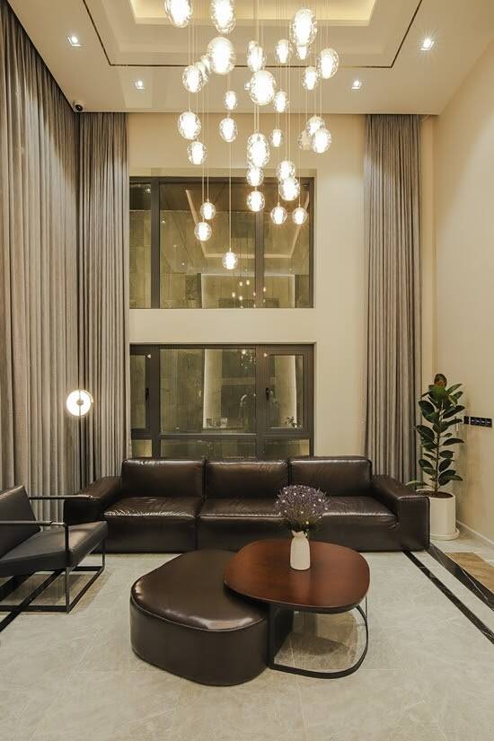 Phòng khách được thiết kế trần cao, tạo cảm giác thoáng đãng. Toàn bộ  nội thất  có tông màu nâu vừa sang trọng, vừa ấm cúng.