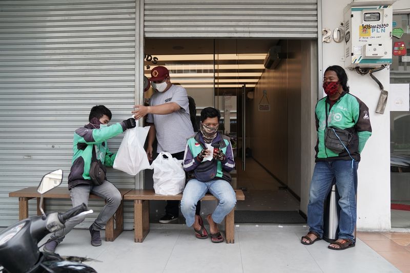 Các tài xế  Gojek  đợi đơn hàng bên ngoài một nhà hàng ở Jakarta vào tháng 5/2020. Ảnh: Bloomberg