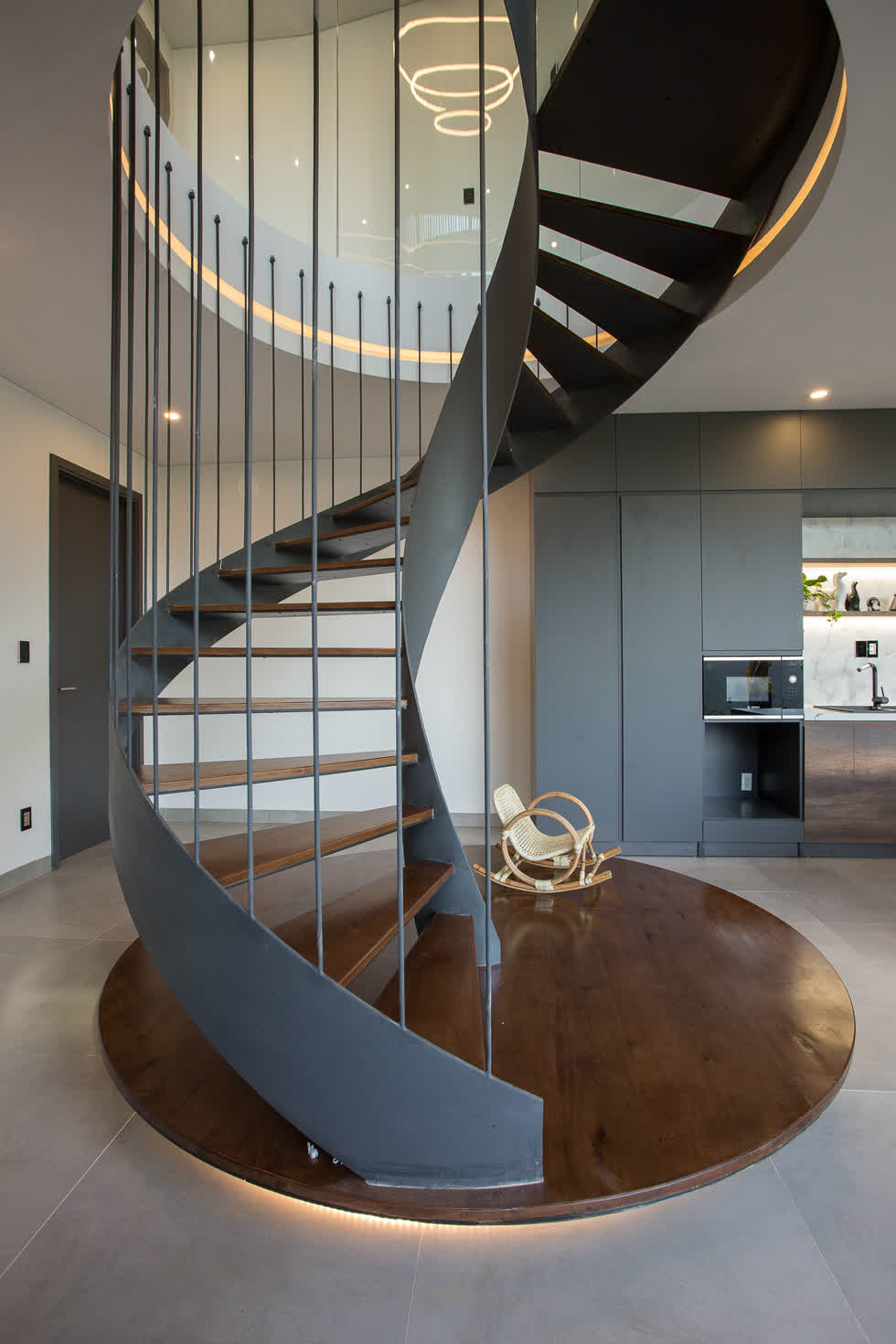 Cầu thang xoắn dẫn lối lên tầng 1 không chỉ đáp ứng về mặt công năng sử dụng mà còn mang tính thẩm mỹ, khiến không gian tầng trệt có điểm nhấn ấn tượng .