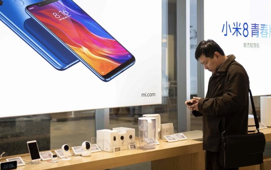 Hình ảnh một người đang tham khảo các sản phẩm của Xiaomi tại Trung Quốc. Ảnh: AFP