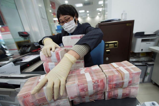   Nhân viên tại Ngân hàng Trung Quốc đeo khẩu trang và găng tay khi tiếp xúc với tiền mặt     (Ảnh: Reuters)  