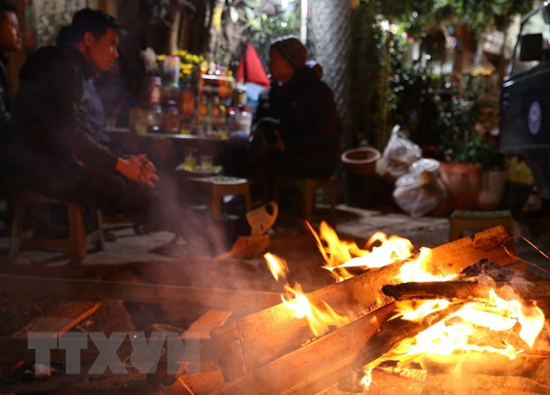   Người dân đốt lửa sưởi ấm trên phố Kim Ngưu, Hà Nội. (Ảnh: Hoàng Hiếu/TTXVN)  
