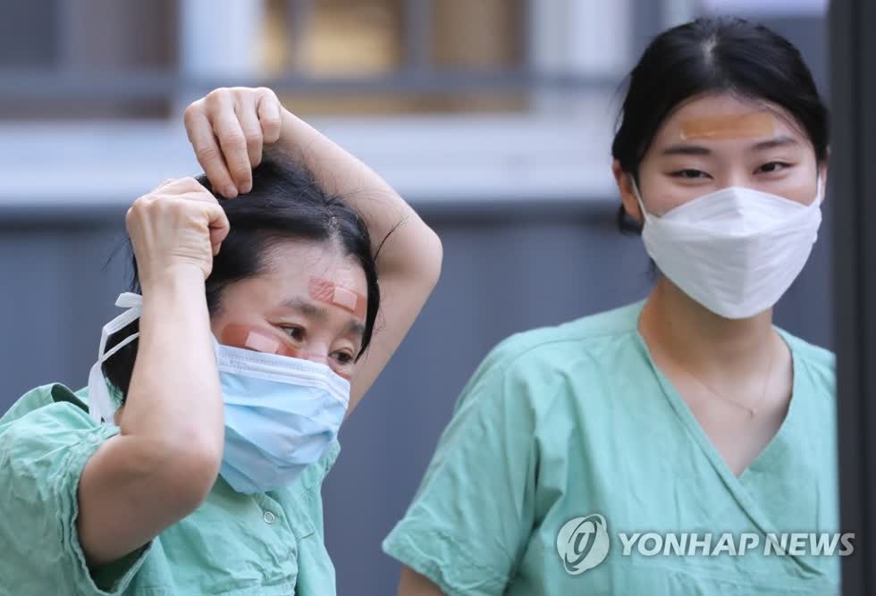   Nhân viên y tế sử dụng miếng dán urgo để che vết thương trên mặt do đeo kính bảo hộ trong nhiều giờ trong khi điều trị bệnh nhân nhiễm Covid-19 tại Bệnh viện Dongsan ở Daegu ngày 4/3/. Ảnh: Yonhap  