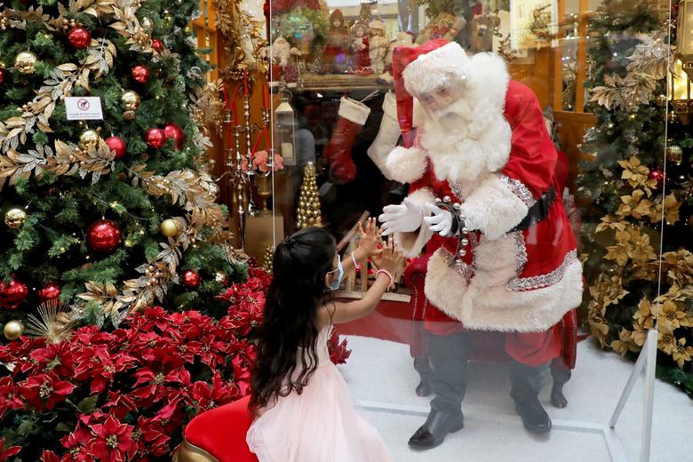  Trong ảnh, ông già Noel ngồi bên trong một bong bóng và giao lưu với trẻ em qua lớp kính. Nguồn: Reuters