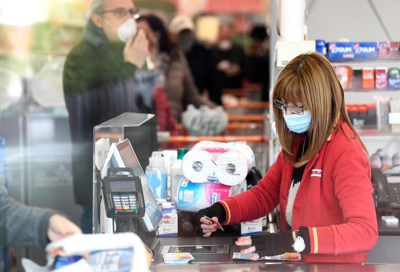   Một nhân viên bán hàng đeo khẩu trang tại một siêu thị ở thị trấn Casalpusterlengo, nơi đã bị chính phủ Ý đóng cửa do dịch bệnh virus corona ở miền bắc nước này.  