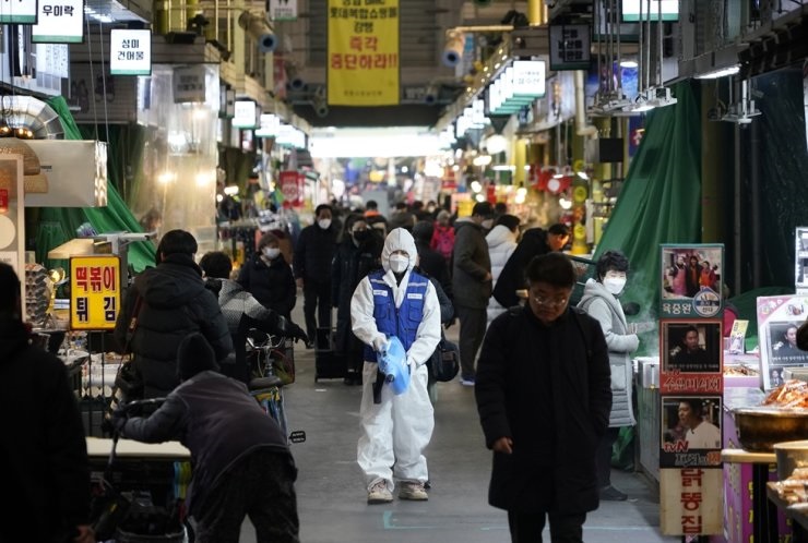   Một nhân viên từ công ty dịch vụ khử trùng vệ sinh sàn tại khu chợ truyền thống ở Seoul hôm 24/2. Ảnh: Reuters.  