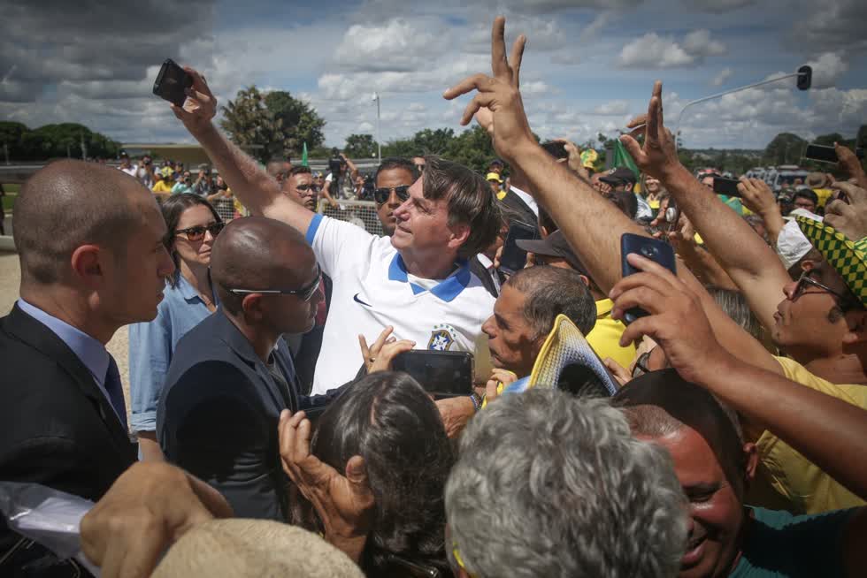 Tổng thống Brazil Jair Bolsonaro, người sau đó bị nhiễm COVID-19, chụp ảnh selfie với những người ủng hộ trong cuộc biểu tình ở Brasilia vào ngày 15/3. Ảnh: Bloomberg