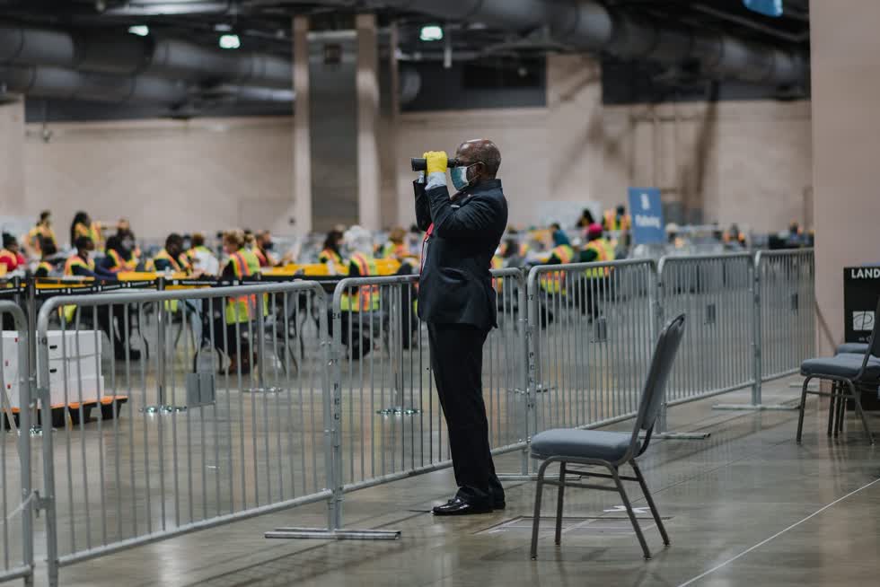 Ở Philadelphia, một người theo dõi cuộc thăm dò sử dụng ống nhòm để theo dõi số phiếu trong cuộc bầu cử tổng thống Mỹ diễn ra vào ngày 3/11. Ảnh: Bloomberg
