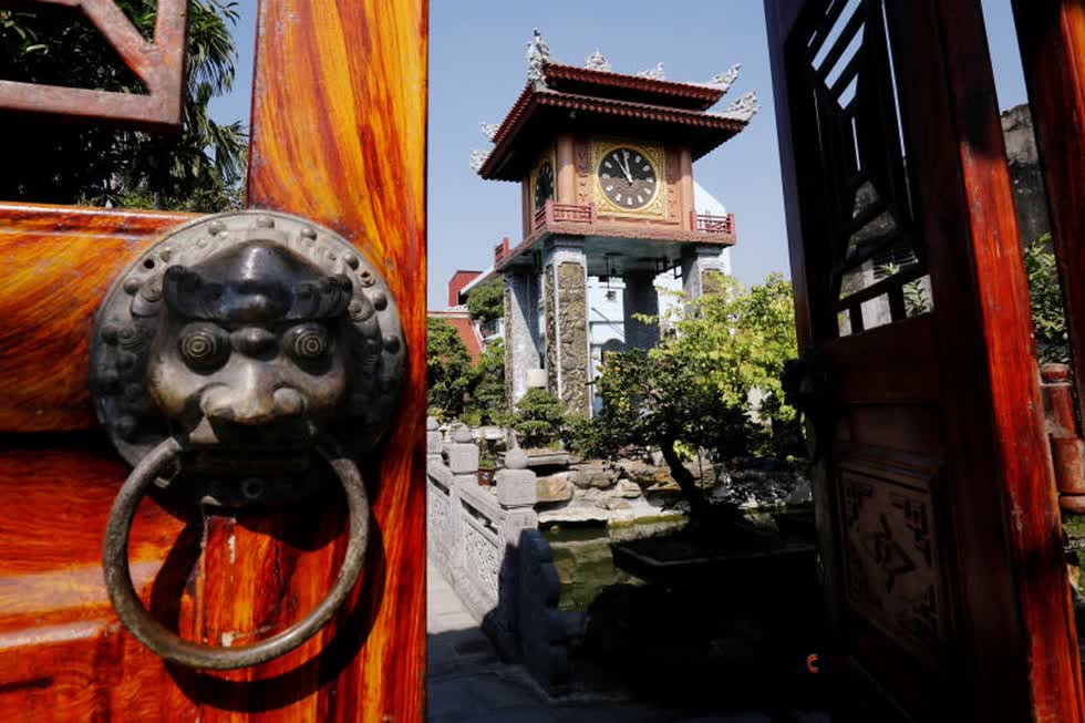 Một chiếc đồng hồ thờ cổ của châu Âu được bày trí tại sân nhà của anh Phạm Văn Thuộc. Ảnh: Reuters.