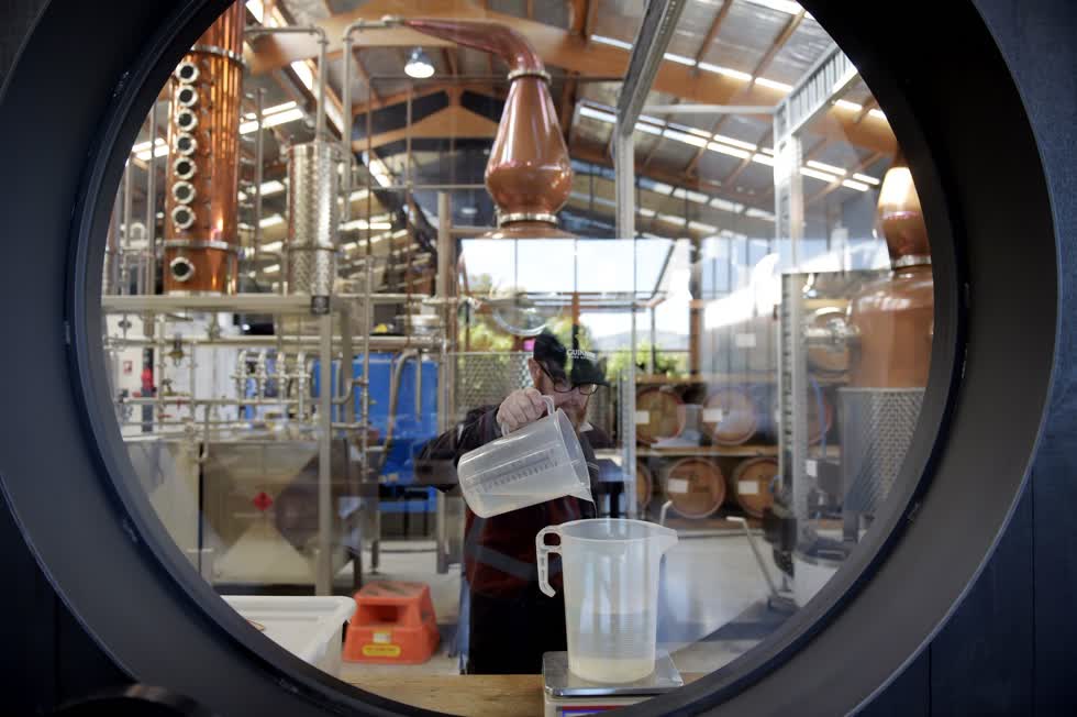 Một người đàn ông sản xuất nước rửa tay tại Nhà máy rượu Gin Four Pillars ở Healesville, Úc, vào ngày 1/4. Nhiều ngành công nghiệp trang bị lại để giải quyết tình trạng thiếu thiết bị bảo hộ và chất khử trùng. Ảnh: Bloomberg